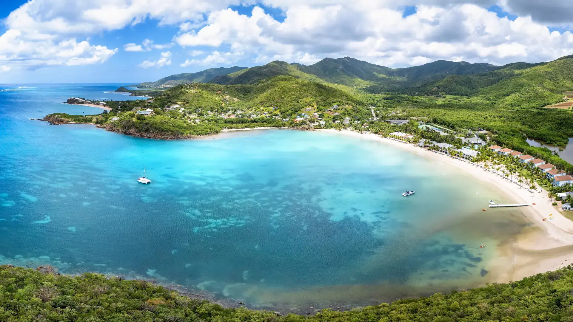 Panoramic aerial view of Carlisle Bay with lush rain forest and turquoise and emerald sea, Antigua and Barbuda, Caribbean