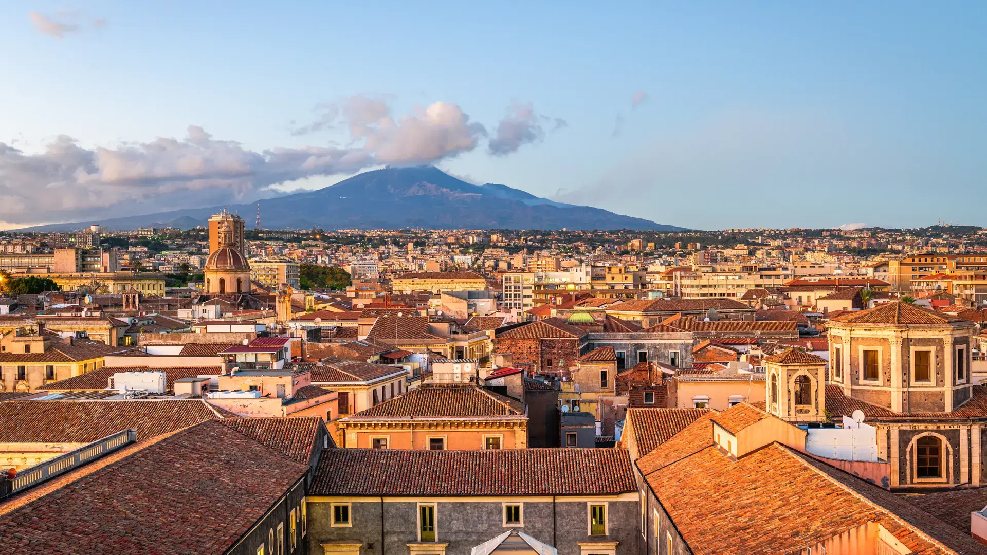 Catania, Sicily, Italy skyline with Mt. Etna at dusk.