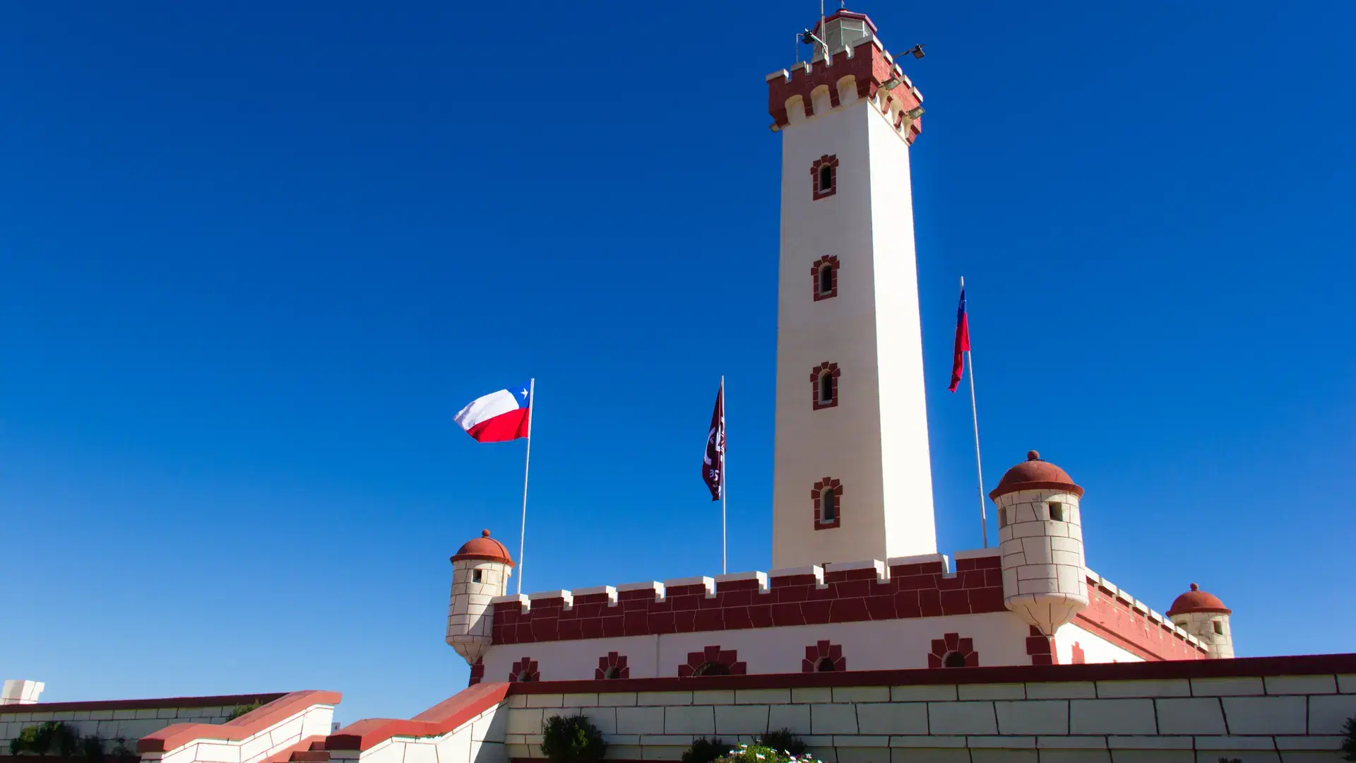Splendid view of La Serena lighthouse on sunny day and Chilean flags blowing in the wind, Chile. South America iconic landmark