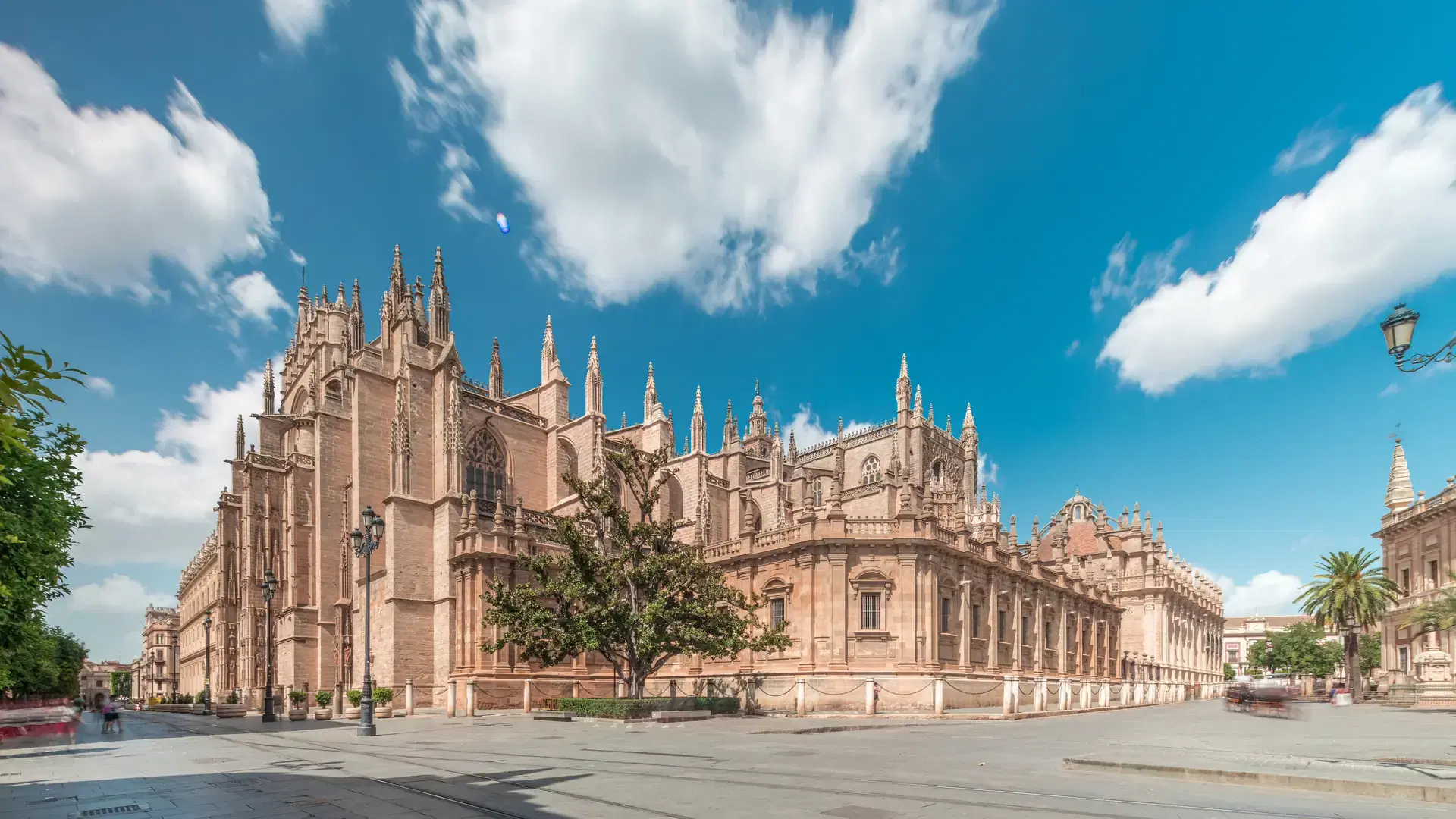 The Seville Cathedral and Giralda Tower timelapse hyperlapse in Seville, Spain. The largest gothic cathedral in the world, UNESCO heritage site, located on Avenue de la Constitucion under a blue sky