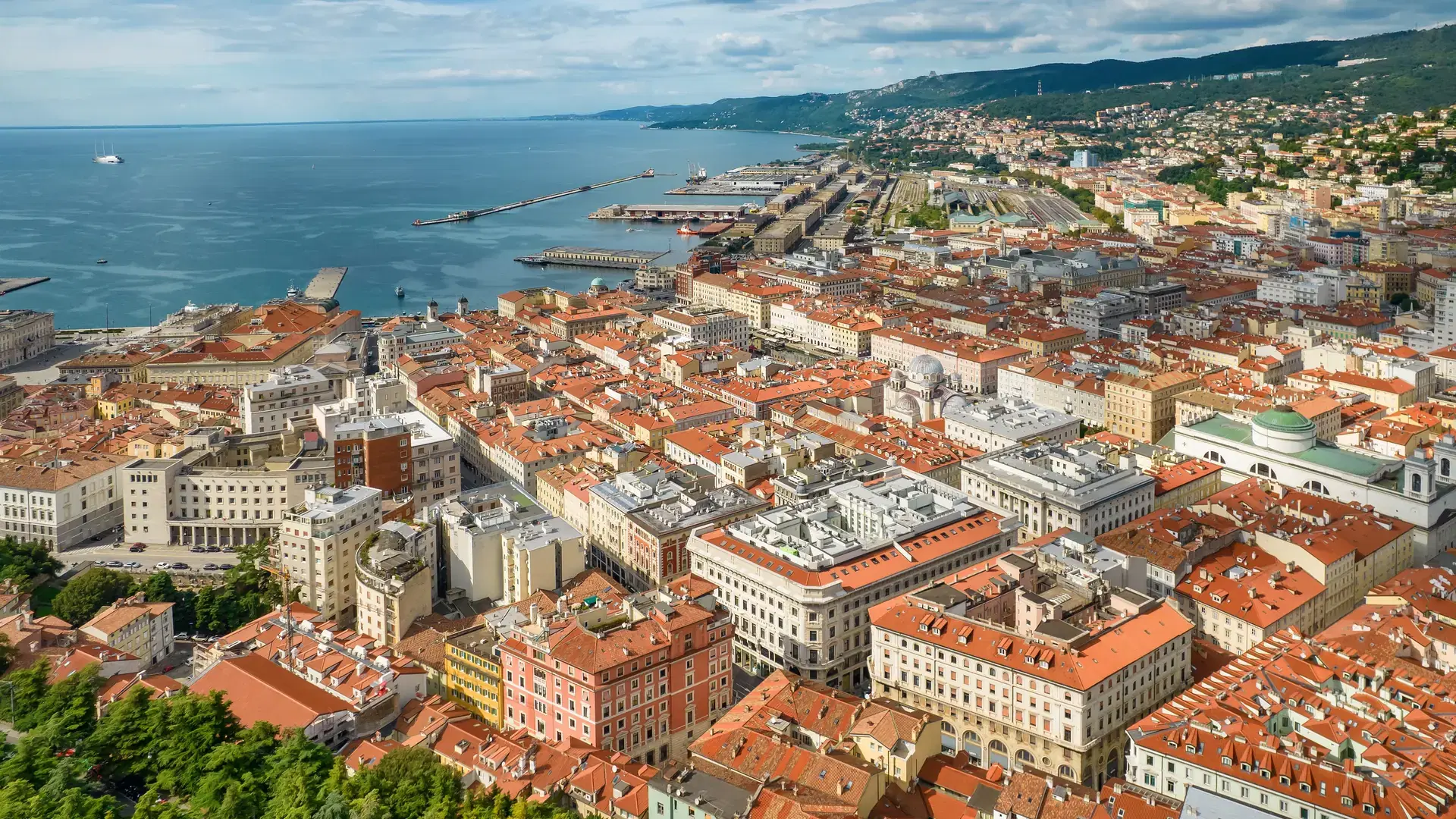Aerial view ot the Trieste city and seaport in northeastern Italy. Cityscape of Trieste on Mediterranean sea coast in Italy.