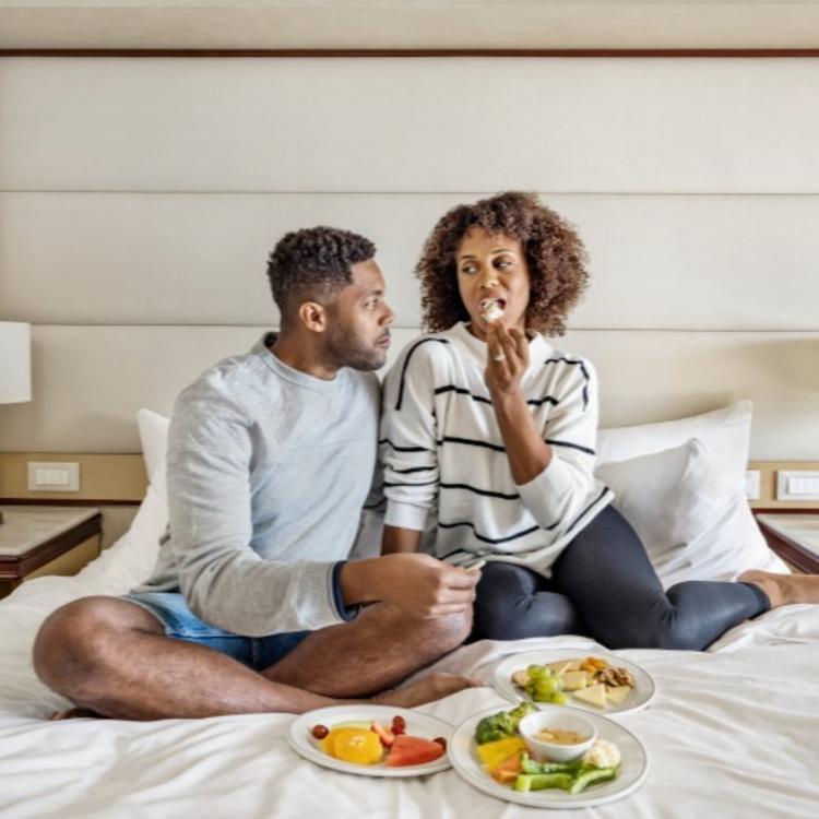 Couple eating on bed
