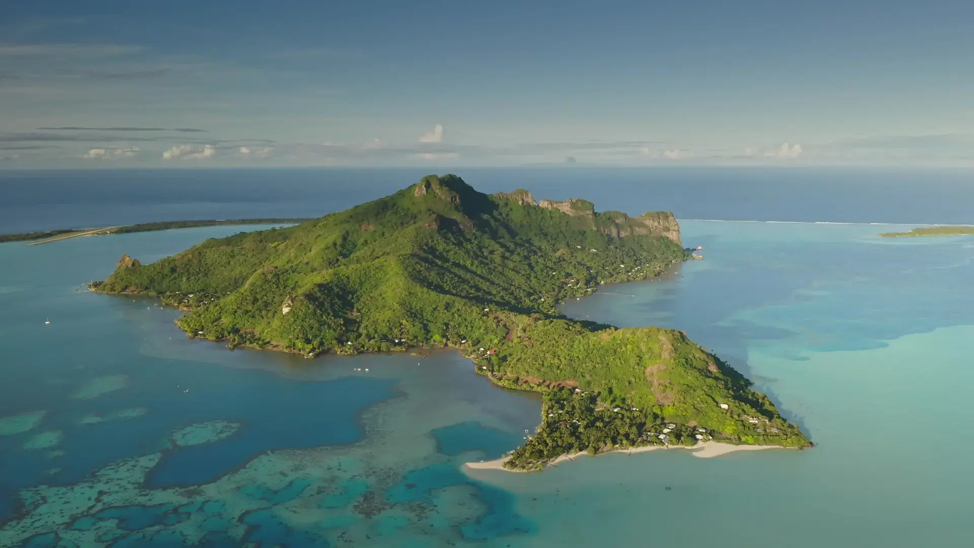 Lush vegetation covers volcanic island of Maupiti, surrounded by turquoise lagoon coral reefs, create a breathtaking tropical paradise in French Polynesia. Remote nature paradise, exotic summer travel