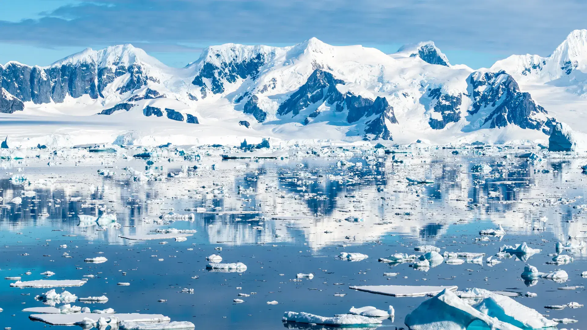 Stunning Mountains Covered with Snow Reflecting in the Water of Antarctica