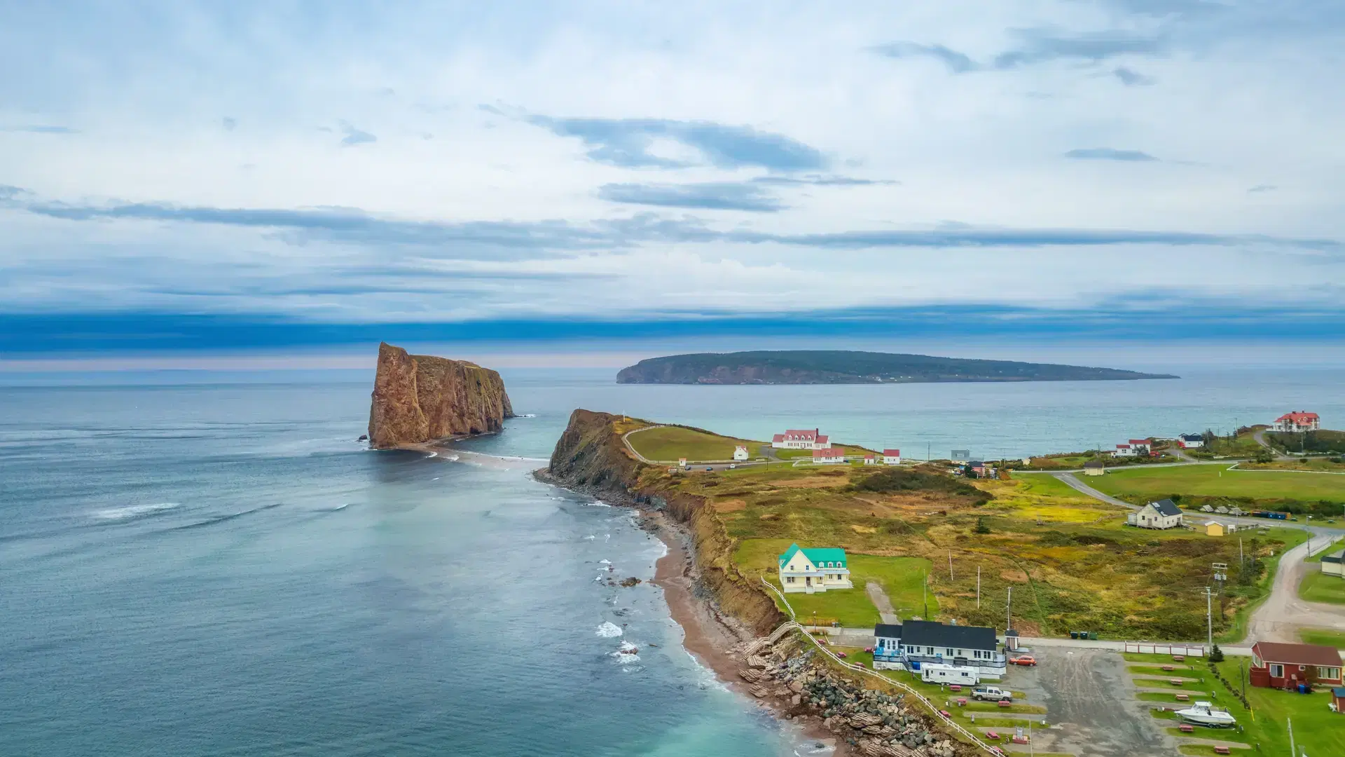 Town on the Atlantic Ocean Coast during a cloudy sunset. Perce, Quebec, Canada. Aerial Panorama