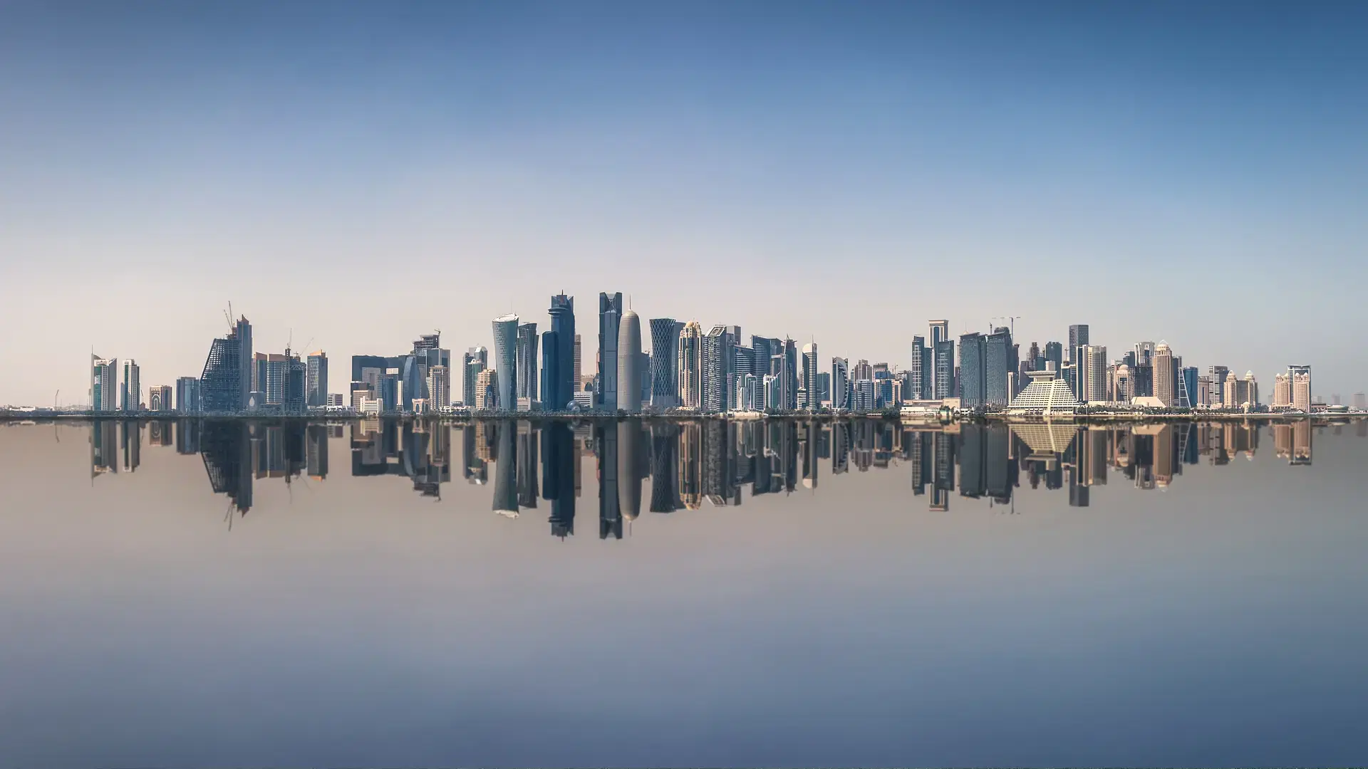 The iconic skyline of Doha, Qatar, with the modern skyscrapers with reflections on the sea