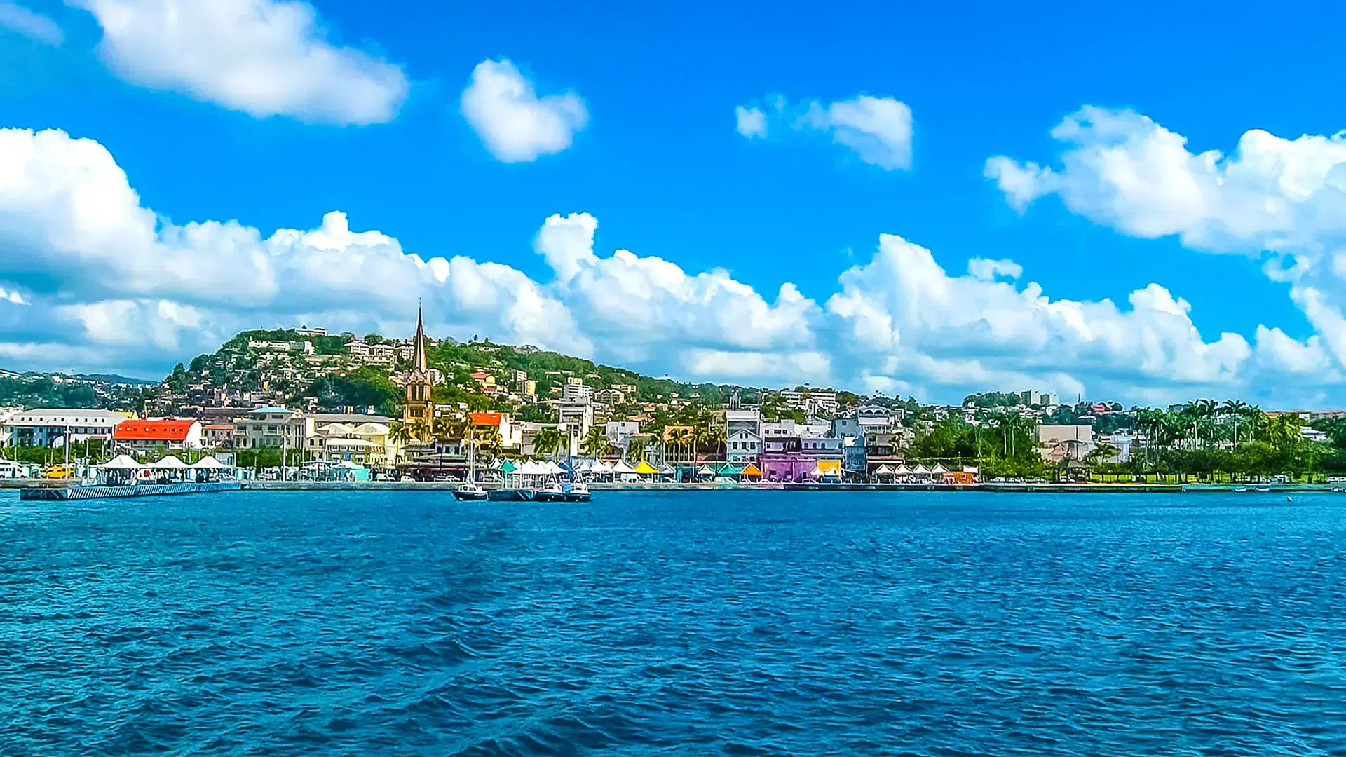 Small yellow boats and many colorful buildings on the coast of Martinique. Image blurred in postproduction