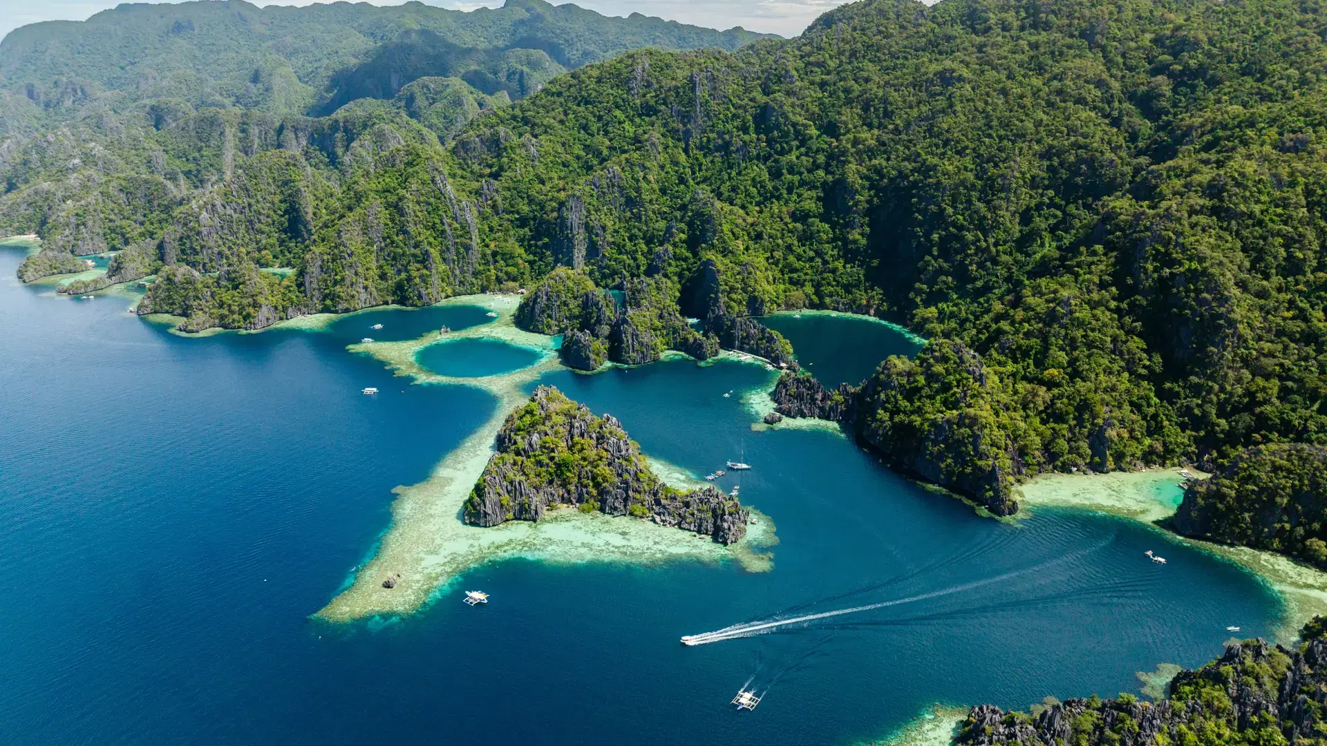 Tropical Islands with tour boats on blue sea. Twin Lagoon. Coron, Palawan. Philippines.