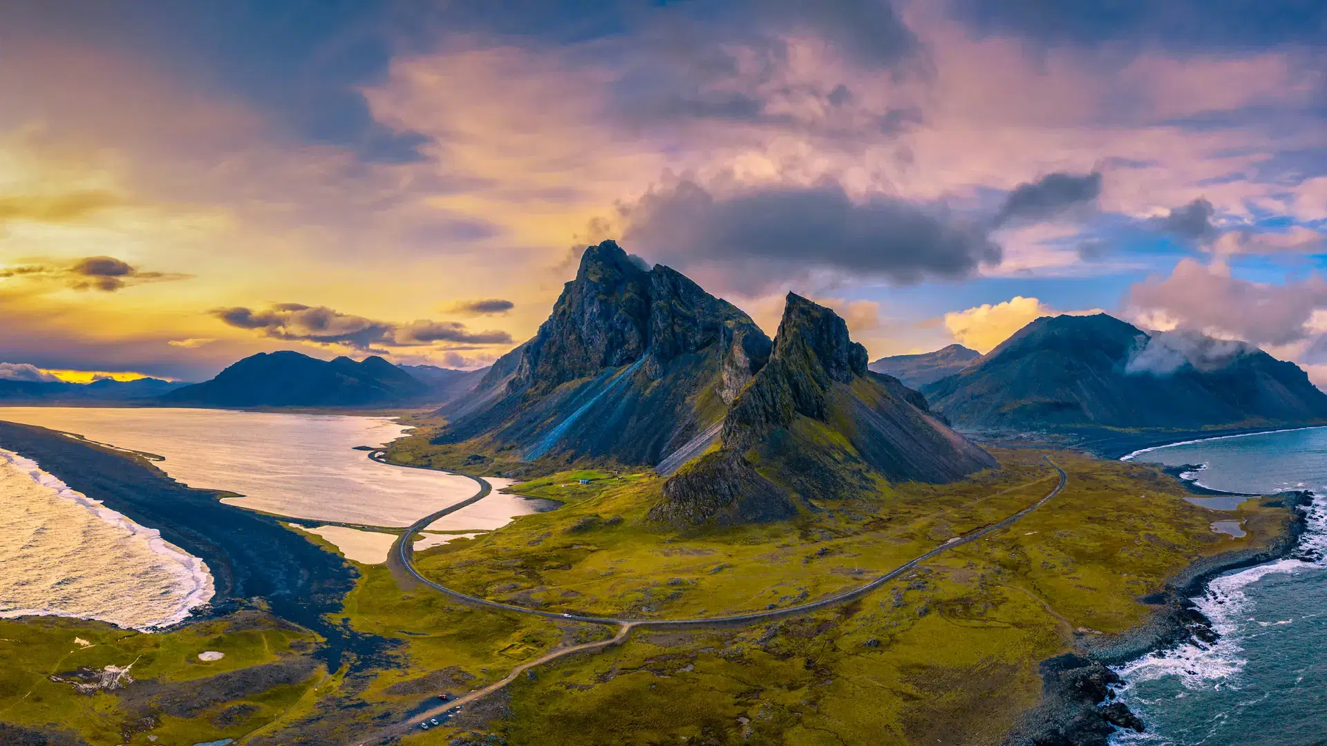 Aerial View of the Eystrahorn with Krossanesfjall Mountain and a nearby black sand beach in Iceland at sunset.