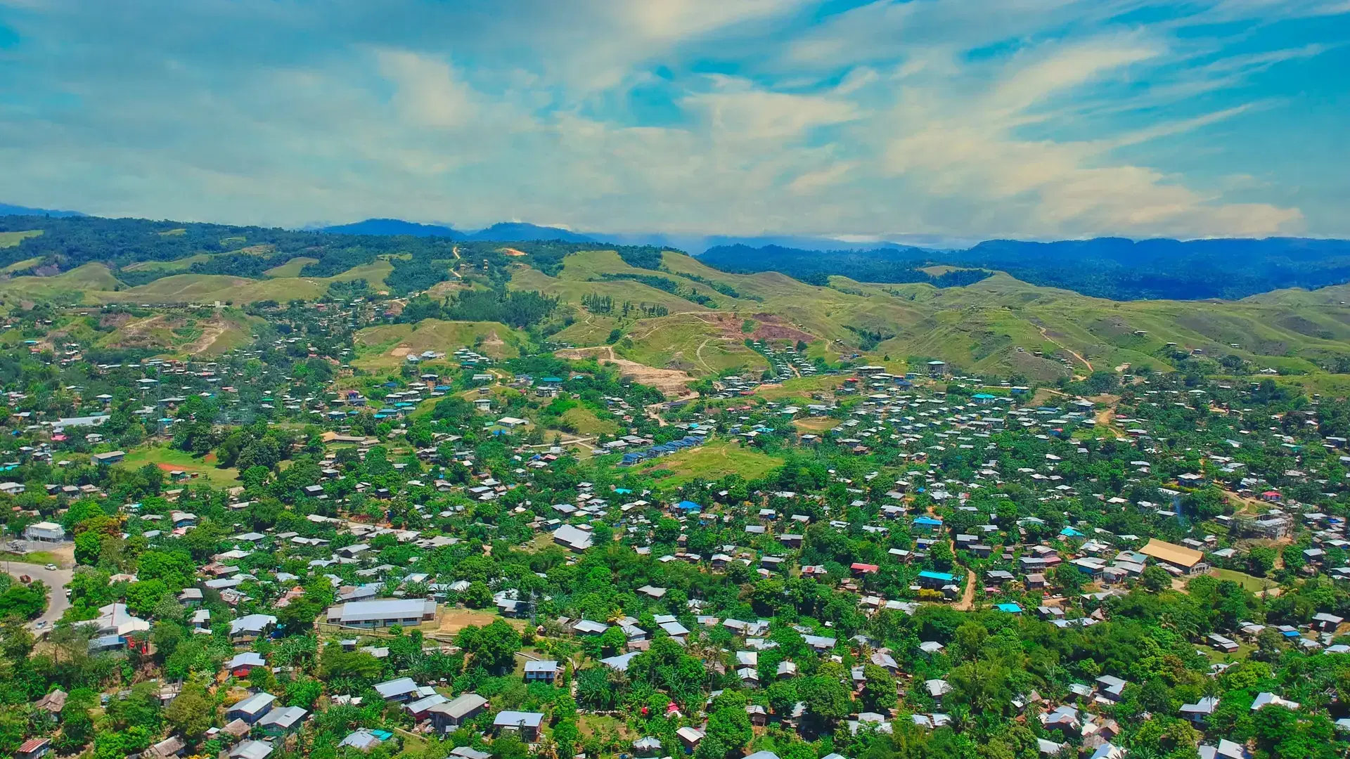 An aerial of houses and nature with the background of mountains in East Honiara, Solomon Islands