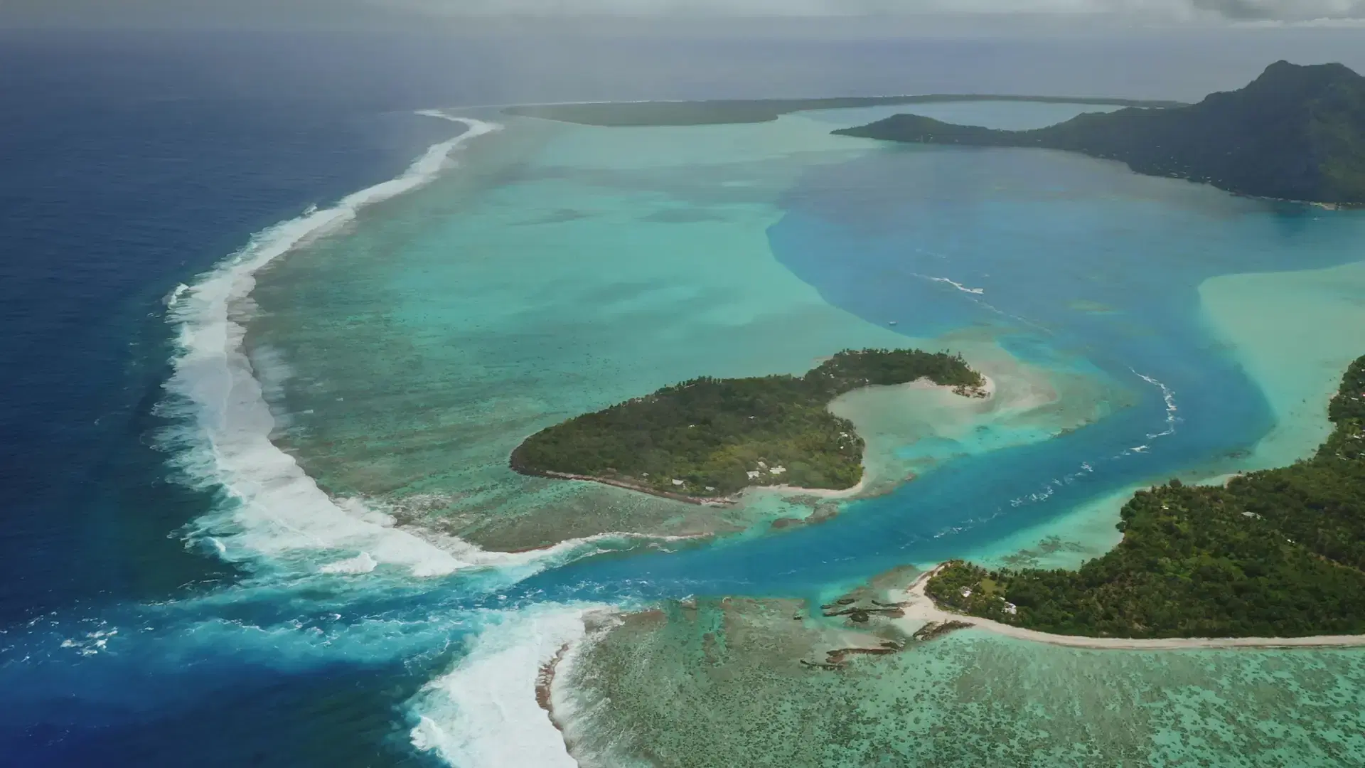 Stunning aerial view capturing huahine, French Polynesia, with lush tropical islands surrounded by vibrant coral reefs and crystal-clear turquoise waters