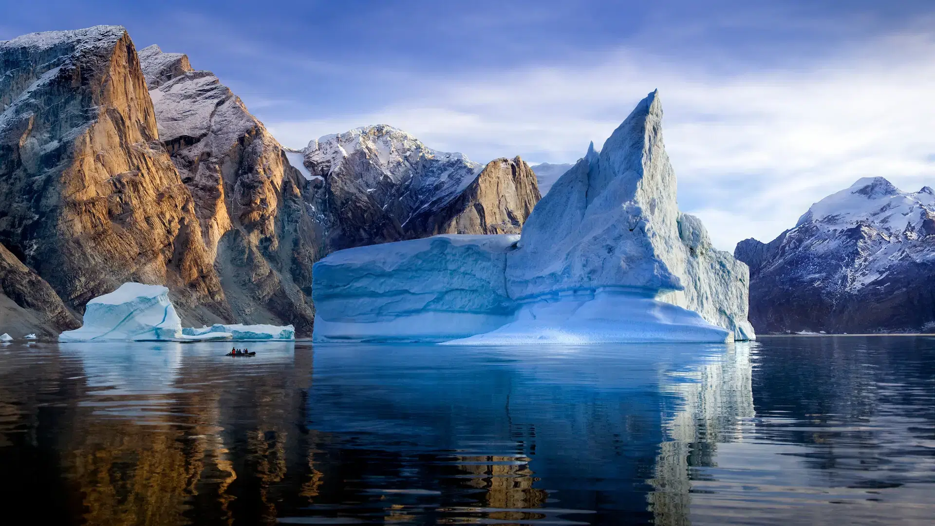 Adventure tourists near icebergs in Franz Joseph Fjord in eastern Greenland