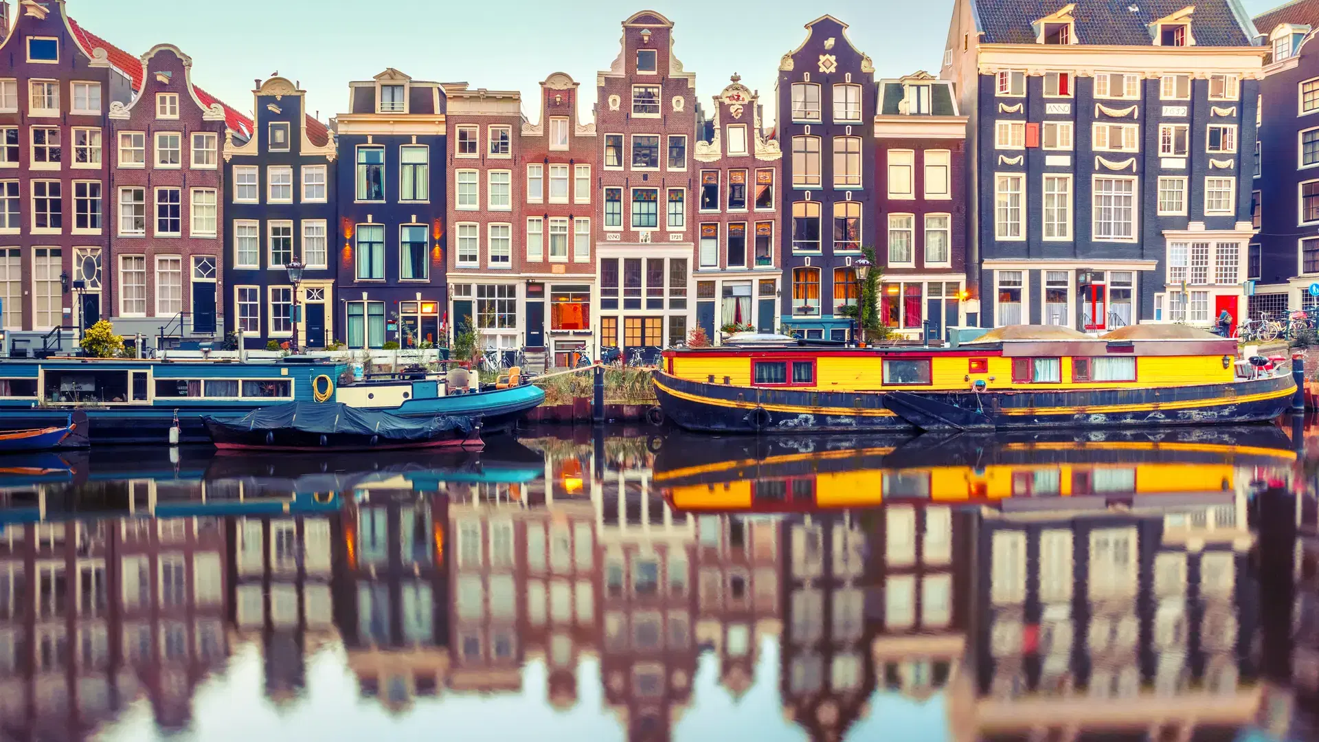 Amsterdam canal Singel with typical dutch houses and houseboats during morning blue hour, Holland, Netherlands. Used toning.