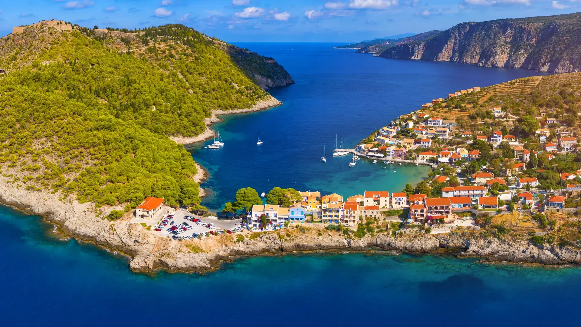 Assos village in Kefalonia, Greece. Turquoise colored bay in Mediterranean sea with beautiful colorful houses in Assos village in Kefalonia, Greece, Ionian island, Cephalonia, Assos village.