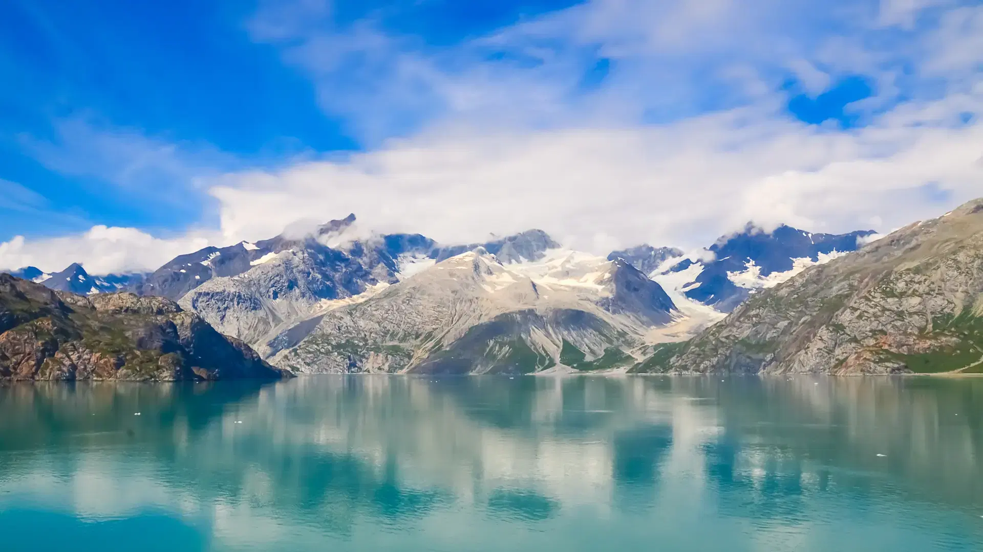 Alaska landscape mountains and water, sunny day. Mountains reflection in the water. Remote location, unplugged. Wild beauty in nature. Untouched environment