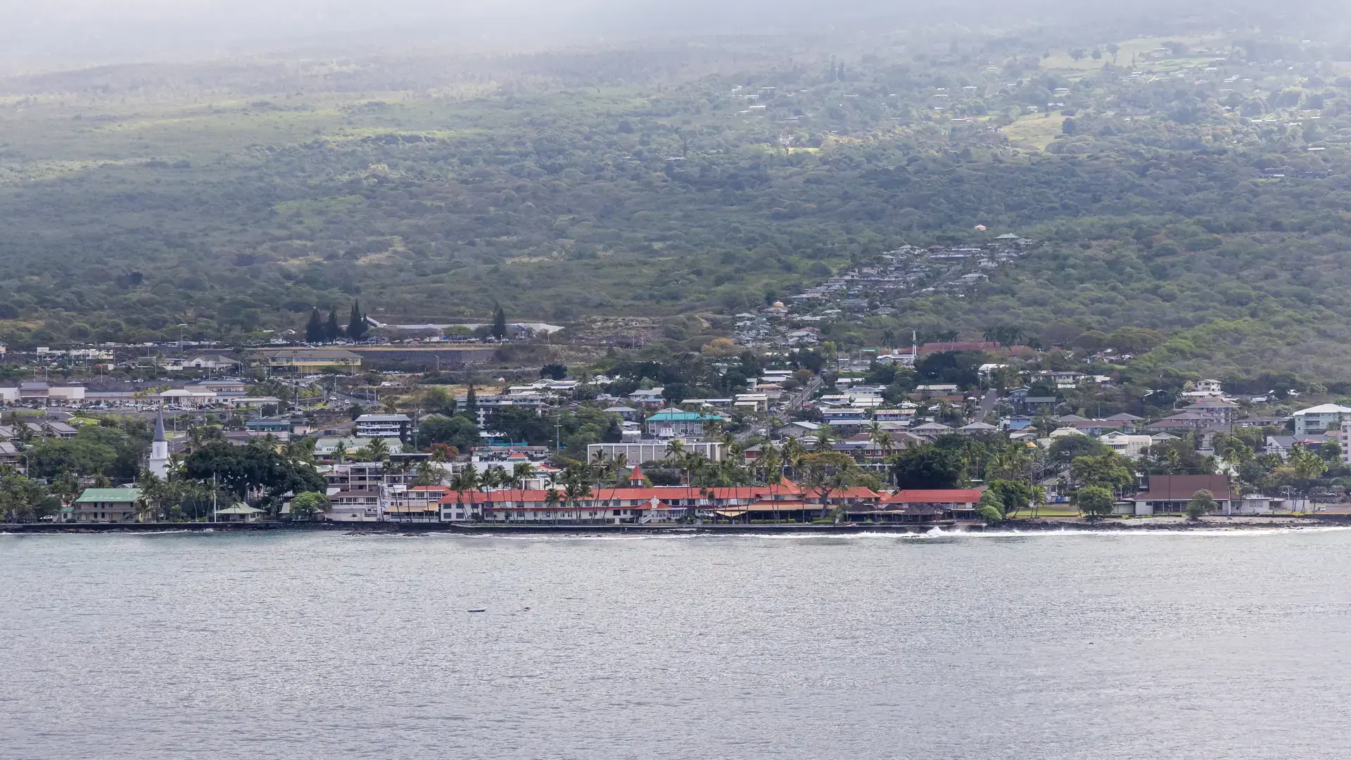 Kailua-Kona in Hawaii featuring the town, coast, and lush landscape in the background.