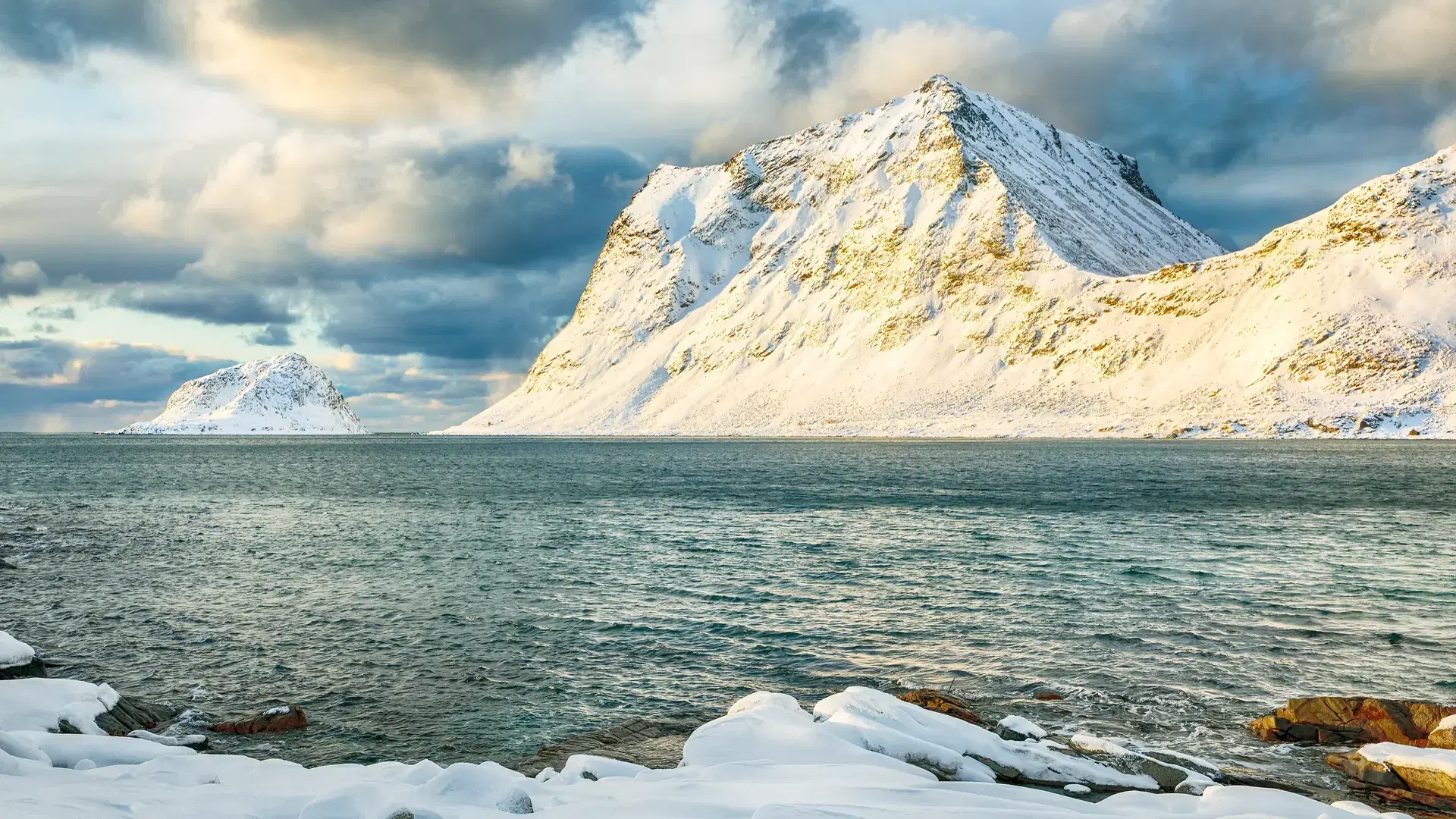 Amazing winter view of Vik and Haukland beaches during sunset with lots of snow and snowy mountain peaks near Leknes. Location: Leknes, Vestvagoy, Lofotens, Norway