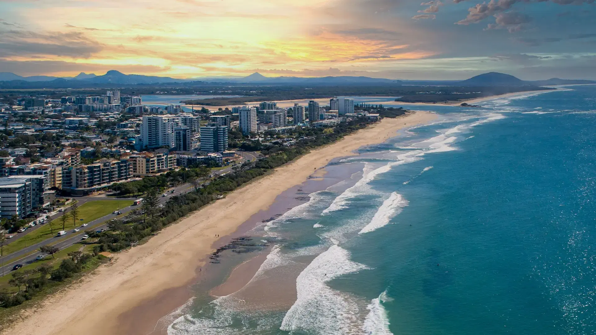 A breathtaking aerial view of the ocean and the city at the sunset in Queensland, Australia
