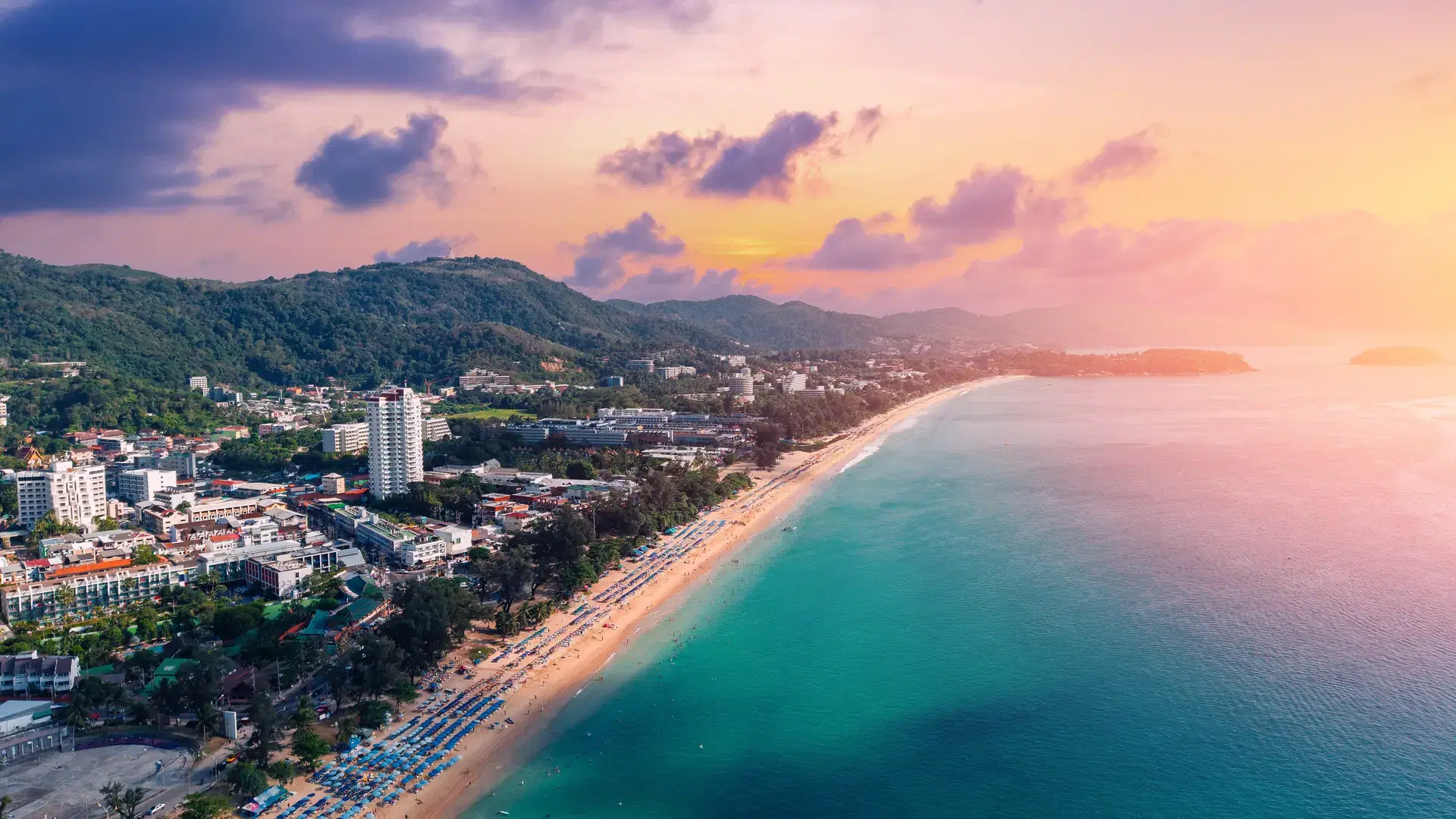 Sunset over karon beach on Phuket island, Thailand, vibrant coastline and scenic beauty.