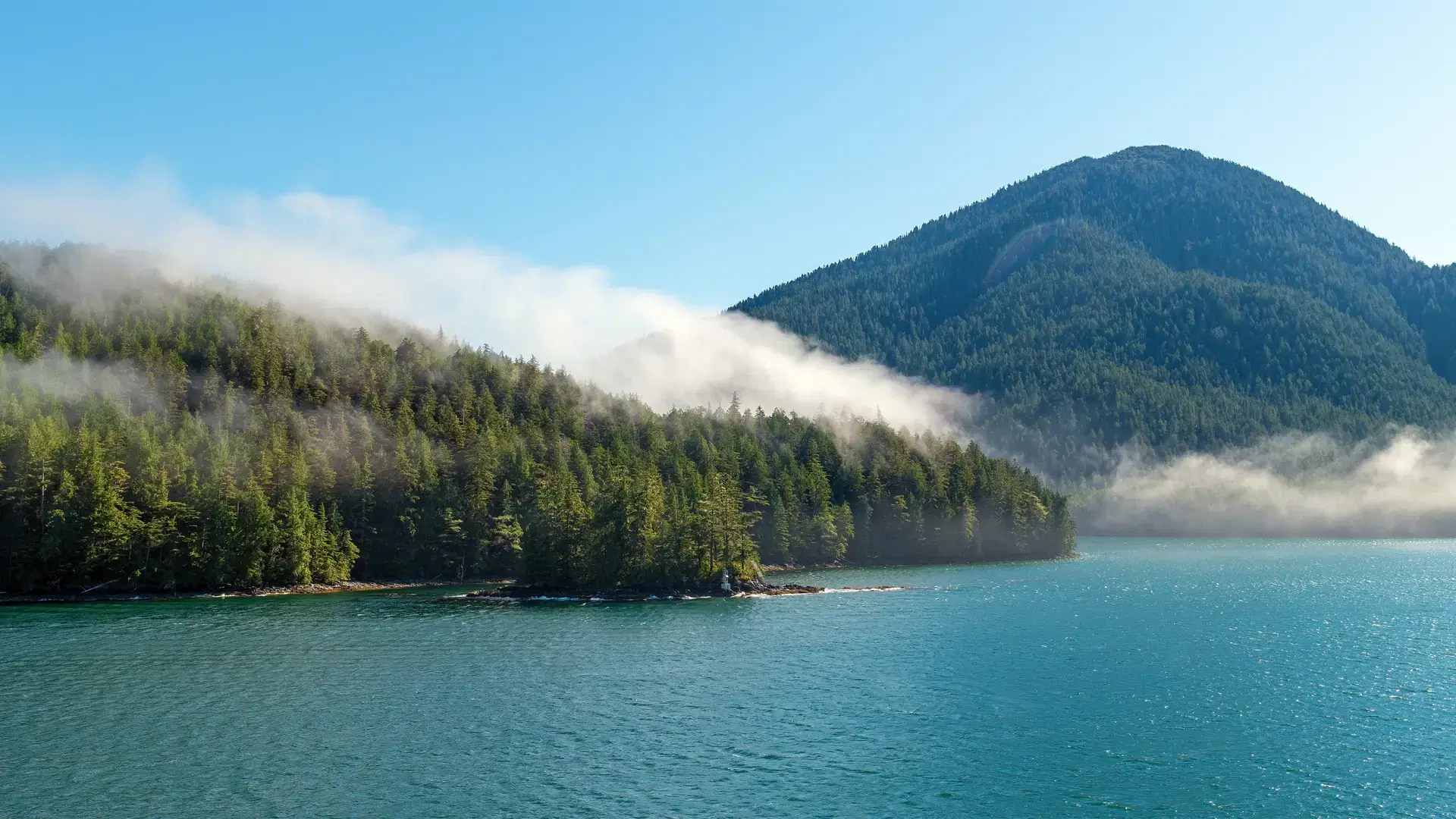 Panorama landscape of islands with pine and cedar trees forest in mist along Inside Passage cruise between Prince Rupert and Port Hardy, Vancouver Island, British Columbia, Canada.