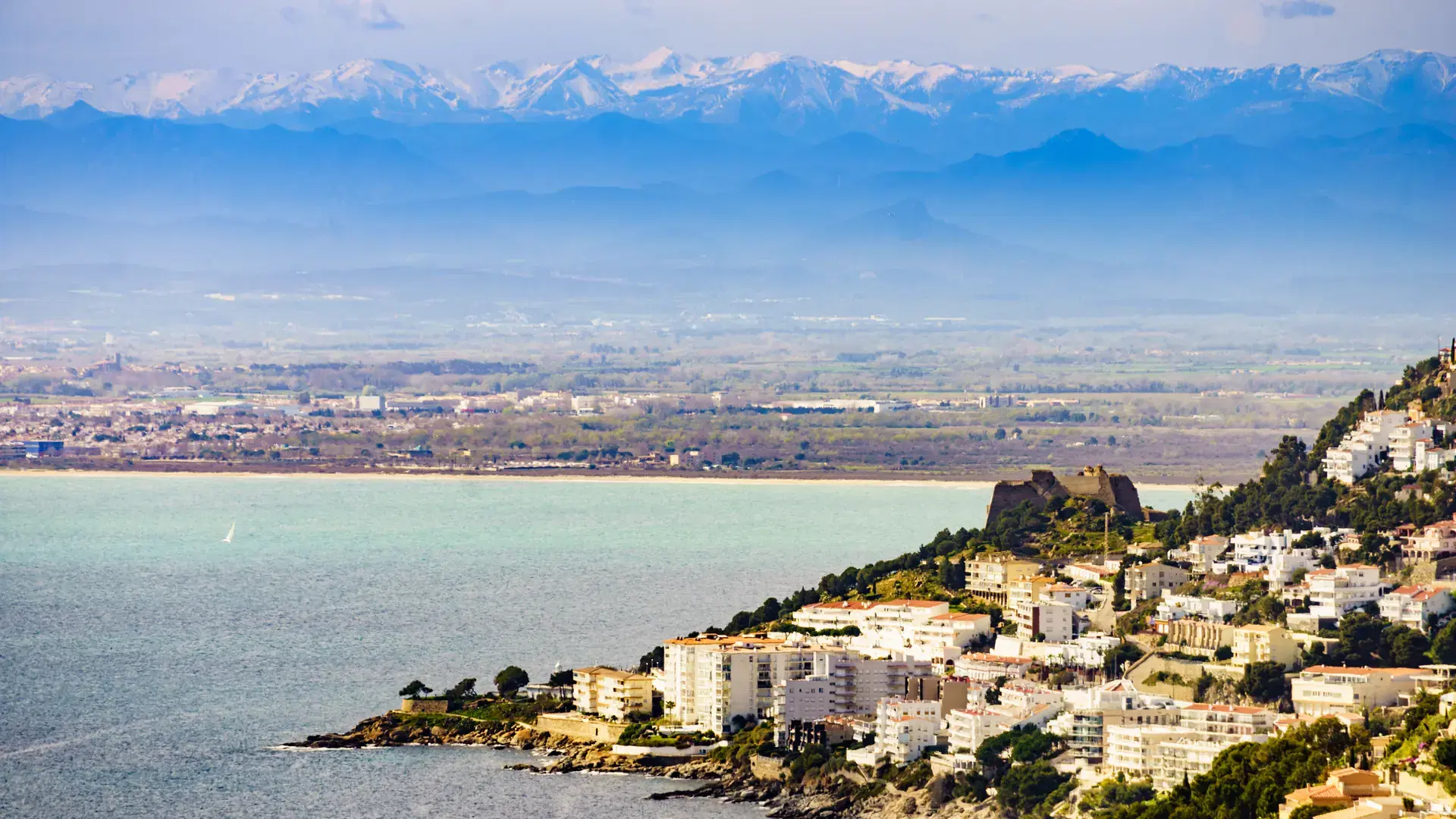 Spanish Mediterranean Costa Brava coastline. Gulf of Roses, province Girona, north of Catalonia, Spain. Mountain range Pyrenees with snowy peaks in the distance.