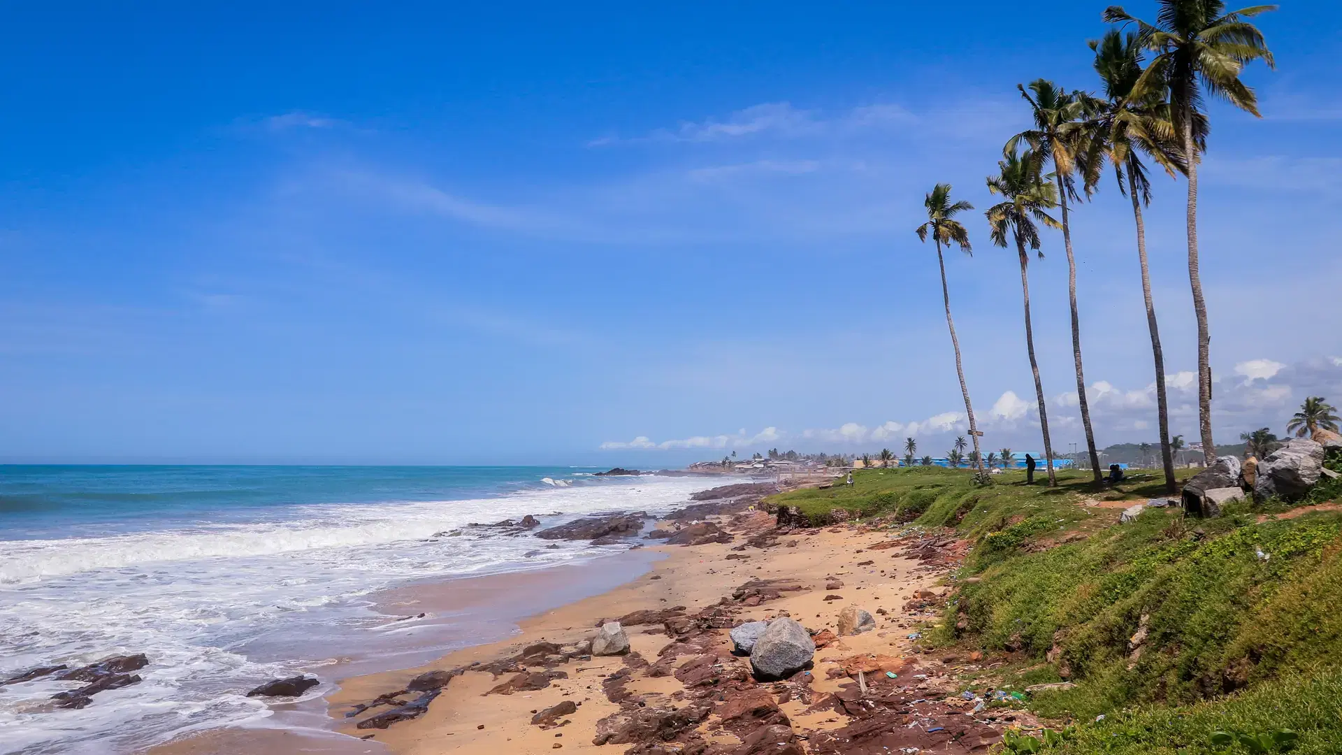 Atlantic Ocean coastline with the turquoise waves among the Palm Trees in Elmina city in Ghana, West Africa